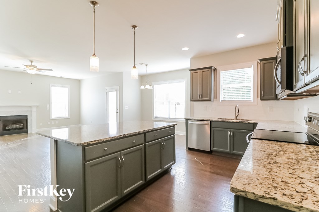 a large kitchen with gray cabinets and marble counter tops