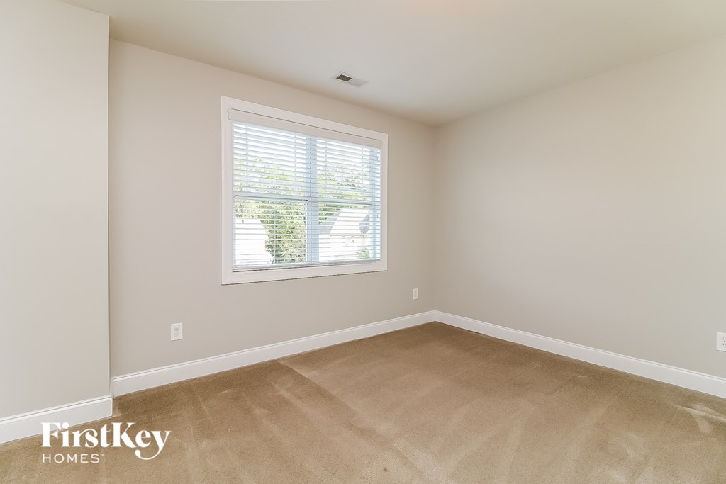 a bedroom with a large window and wooden floors