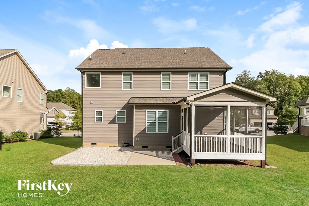 a tan house with a porch and a screened in porch