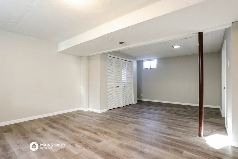an empty living room with wood flooring and white walls