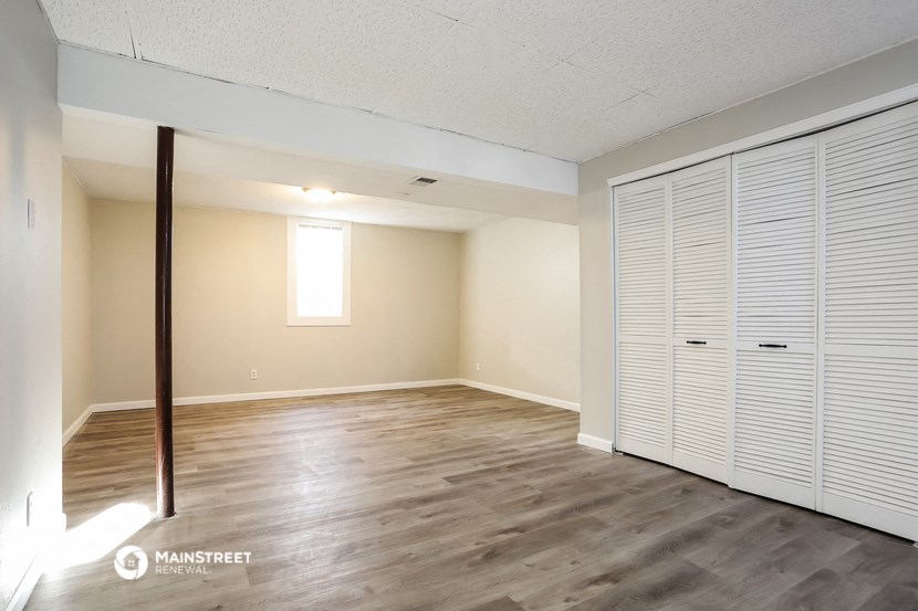 the spacious living room with large closet and wood flooring
