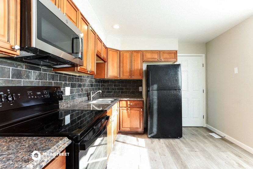 a kitchen with black appliances and wooden cabinets
