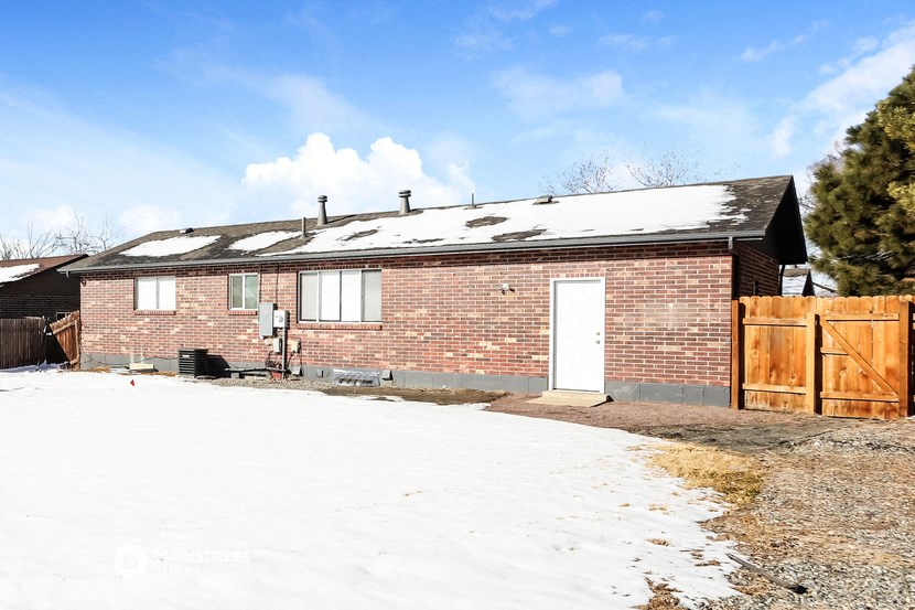 the front of a brick house in the snow
