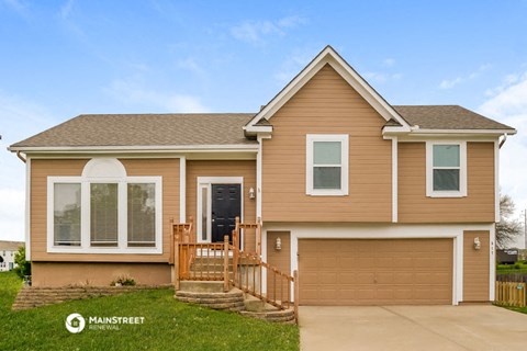 a tan and brown house with a garage door