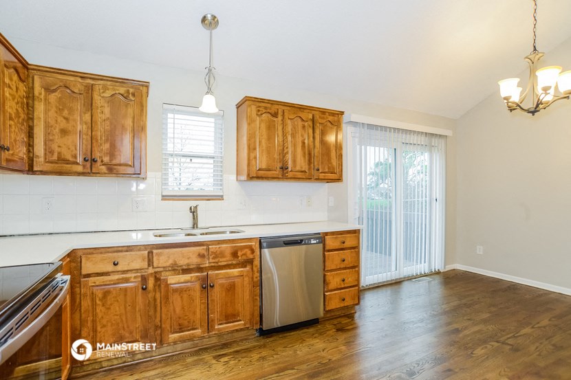 a kitchen with wooden cabinets and a stainless steel dishwasher