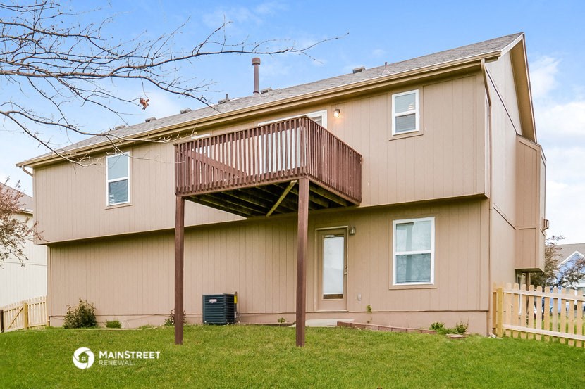a pink house with a deck and a balcony