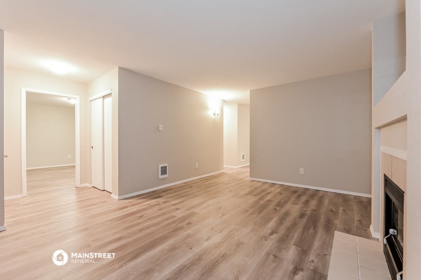 the living room and dining room with wood flooring and a fireplace