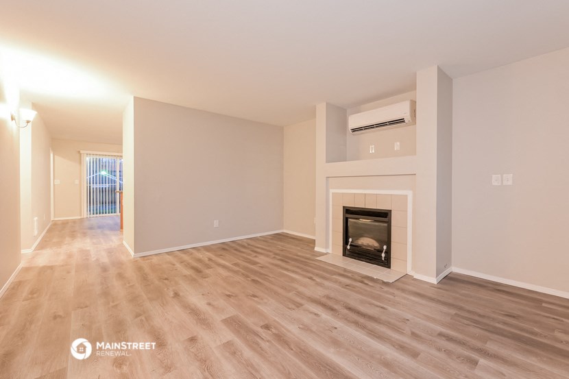 a living room with a fireplace and wooden floors