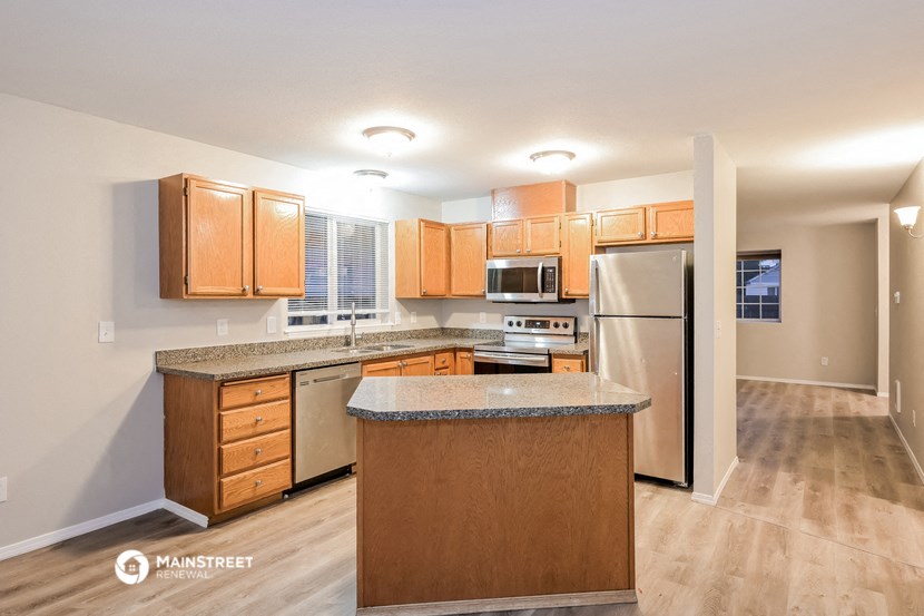 a kitchen with wooden cabinets and stainless steel appliances and a granite counter top
