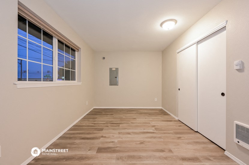 a spacious room with a window and a closet