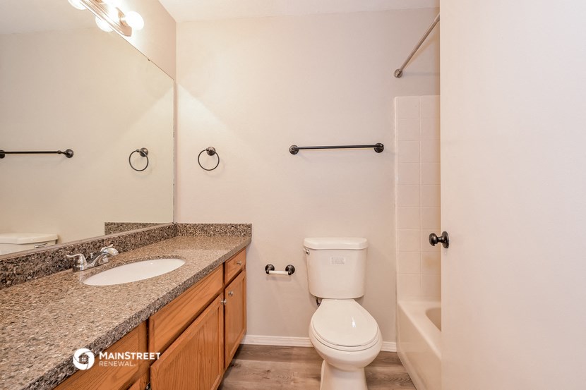 a bathroom with a toilet and a sink and a shower