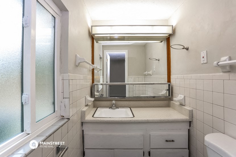 a bathroom with a sink and a mirror and a window