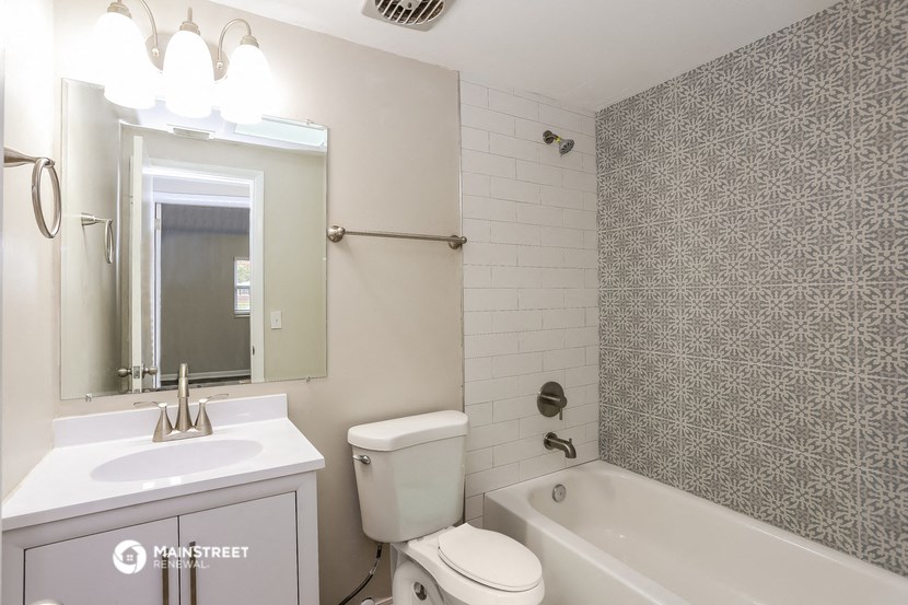 a bathroom with a sink toilet and tub and a mirror