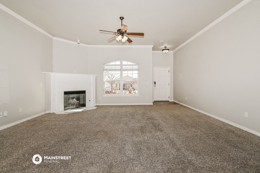 the living room with fireplace and ceiling fan