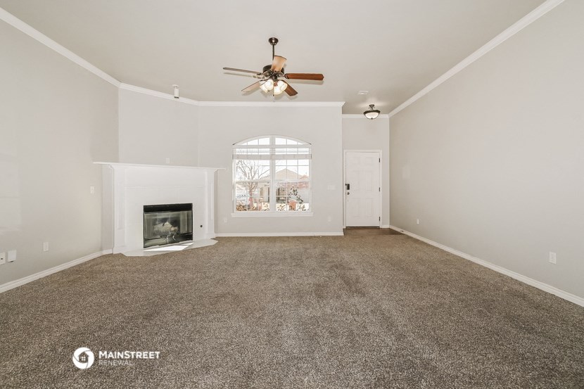 the living room with fireplace and ceiling fan