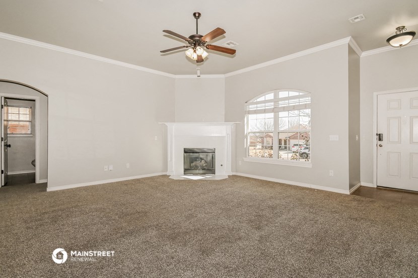 the living room with fireplace and ceiling fan