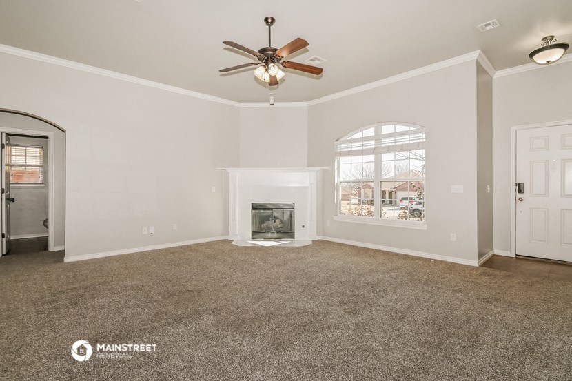 the living room with fireplace and ceiling fan