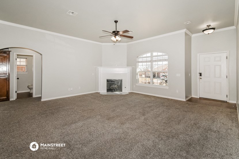 the living room with fireplace and ceiling fan