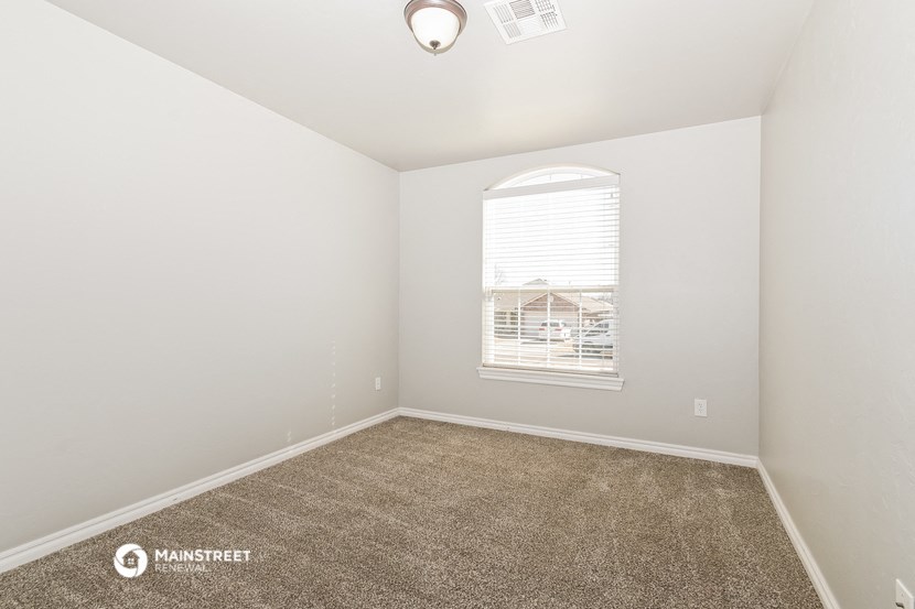 an empty room with carpet and a window