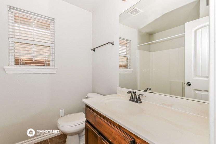 a bathroom with a large mirror and a sink and a toilet