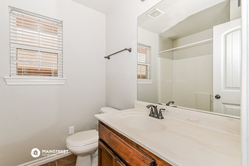 a bathroom with a large mirror and a sink and a toilet