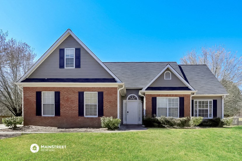 a brick house with black shutters and a white door