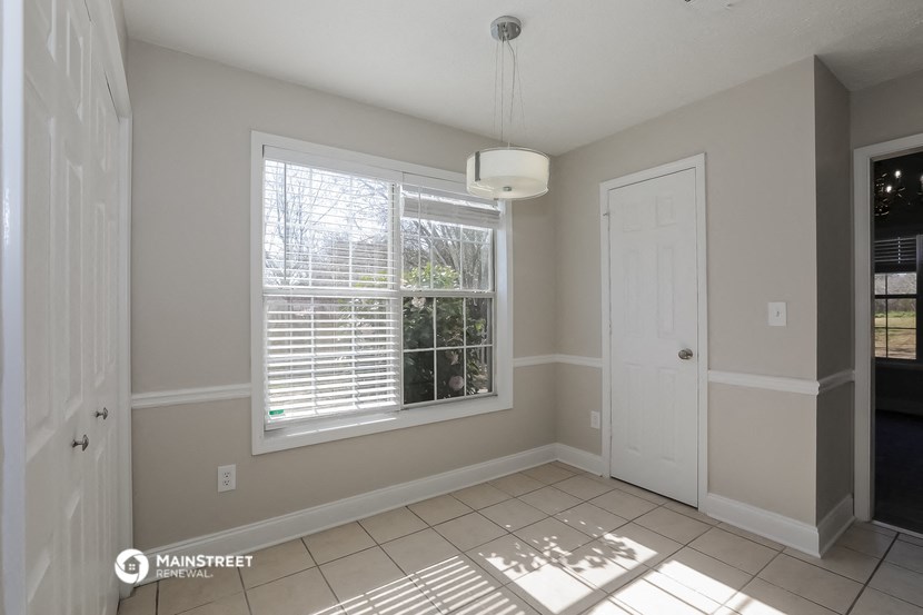 an empty living room with a large window and a white door