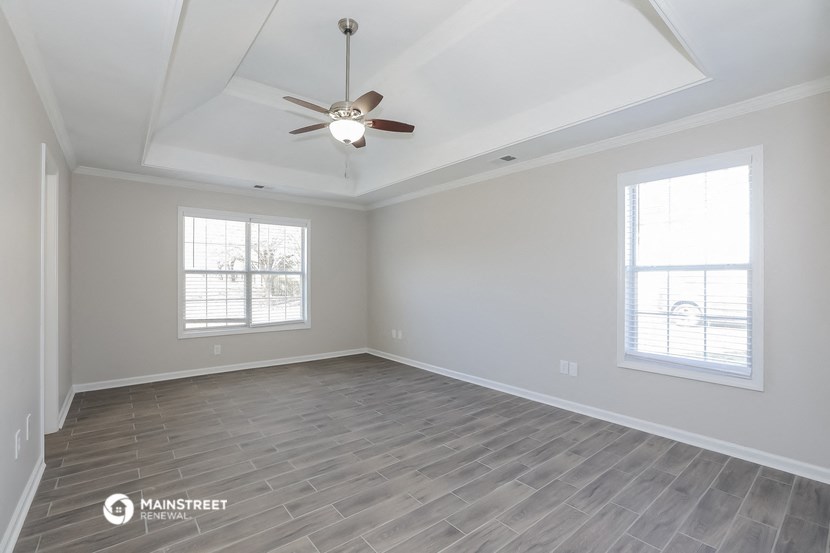 the living room of a new home with a ceiling fan