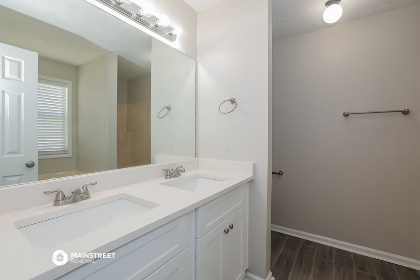 a bathroom with two sinks and a large mirror