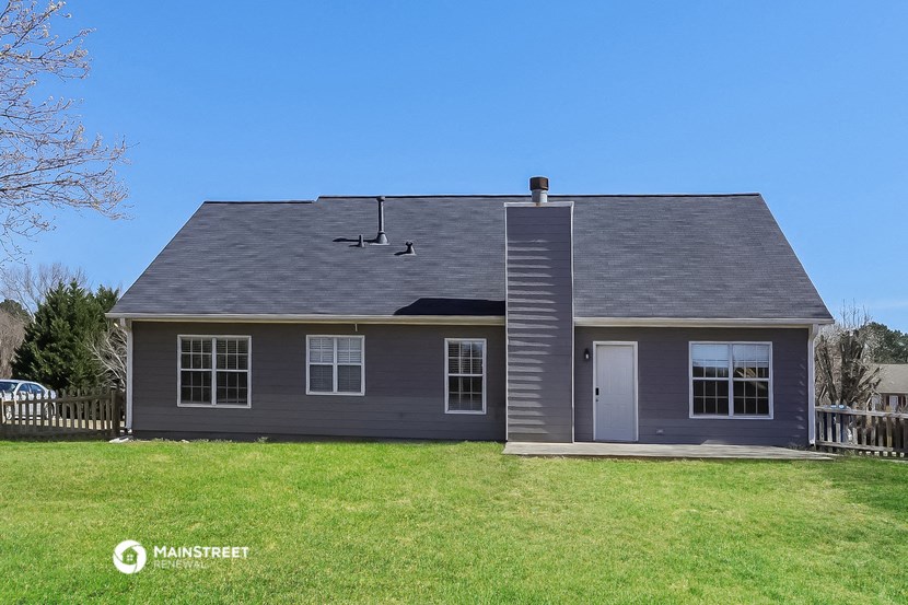 the front of a gray house with a gray roof and a yard