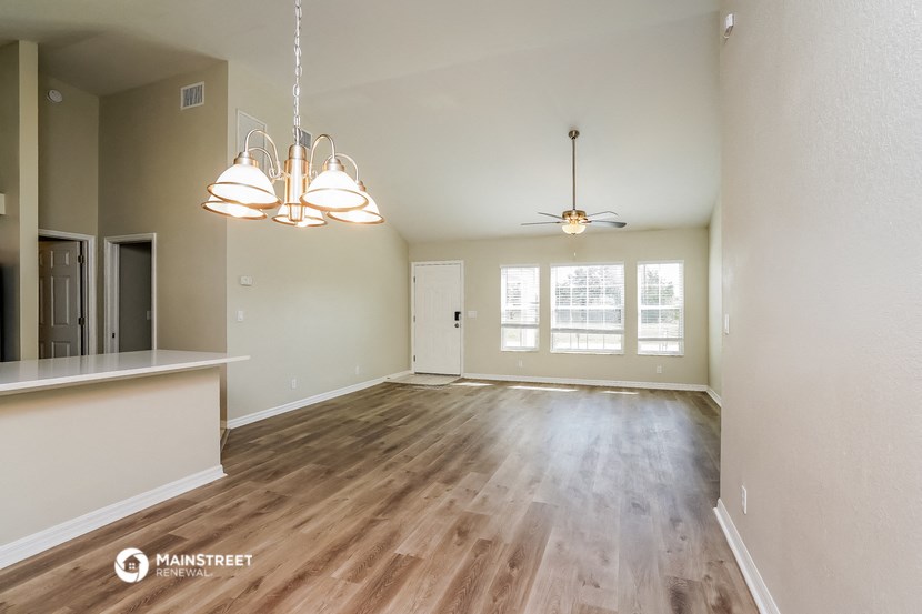 the living room and dining room of an empty house