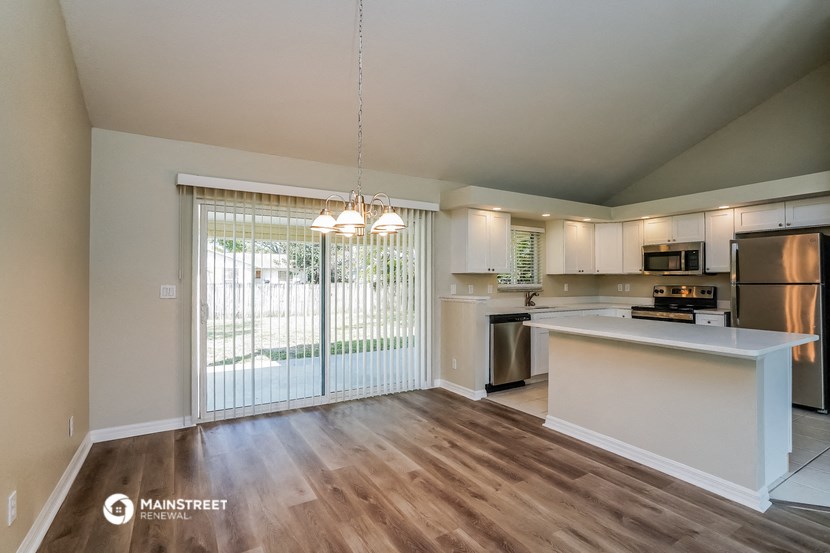 an open kitchen and living room with a sliding glass door