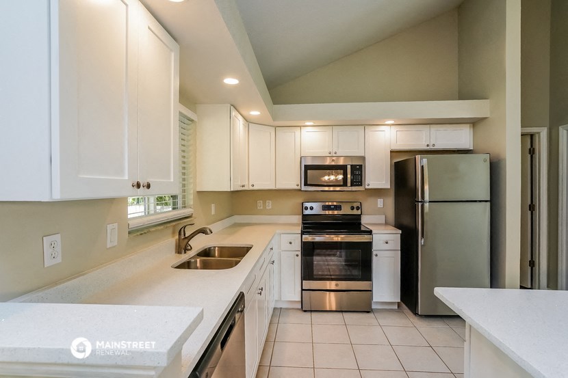 a kitchen with white cabinets and stainless steel appliances