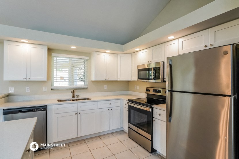 a white kitchen with stainless steel appliances and white cabinets