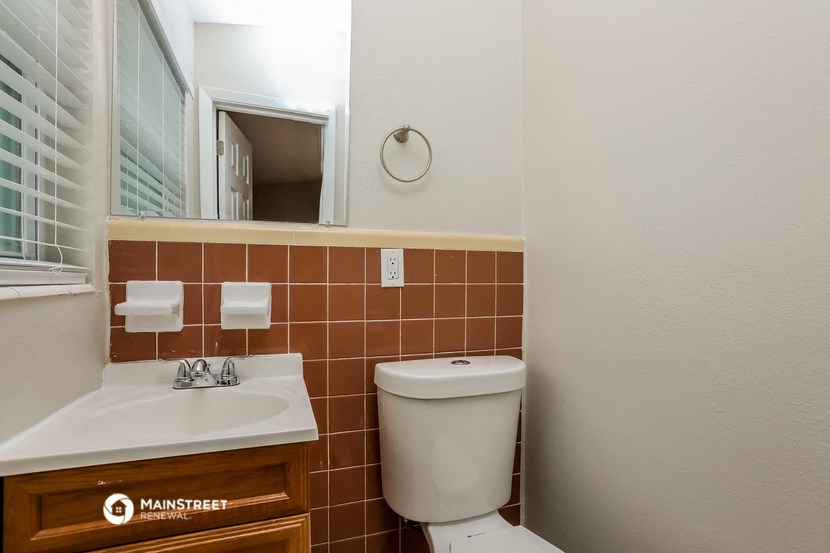 a bathroom with a toilet and a sink and a mirror