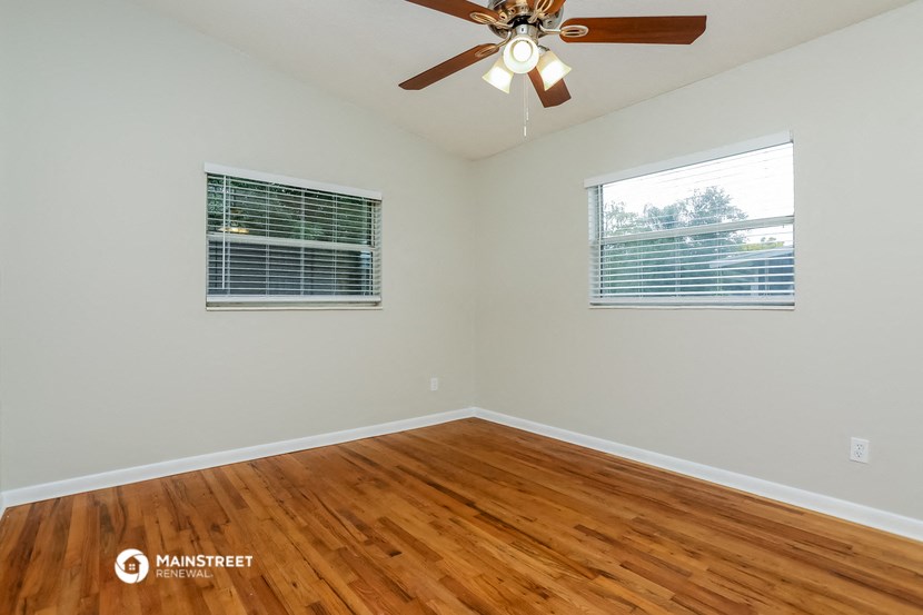 the bedroom with hardwood floors and a ceiling fan