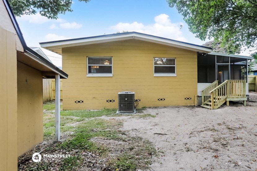a yellow house with a dirt yard in front of it