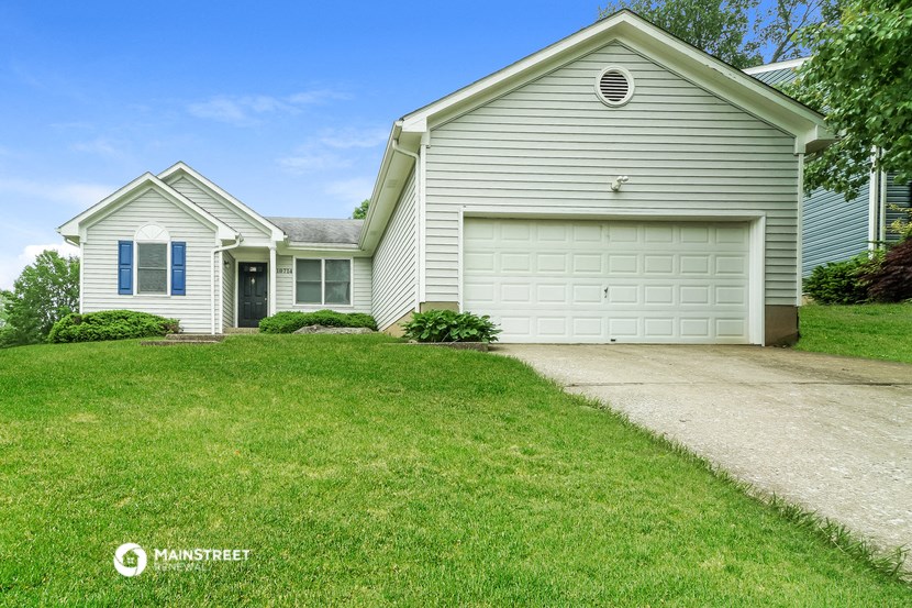 a white house with a white garage door and a lawn
