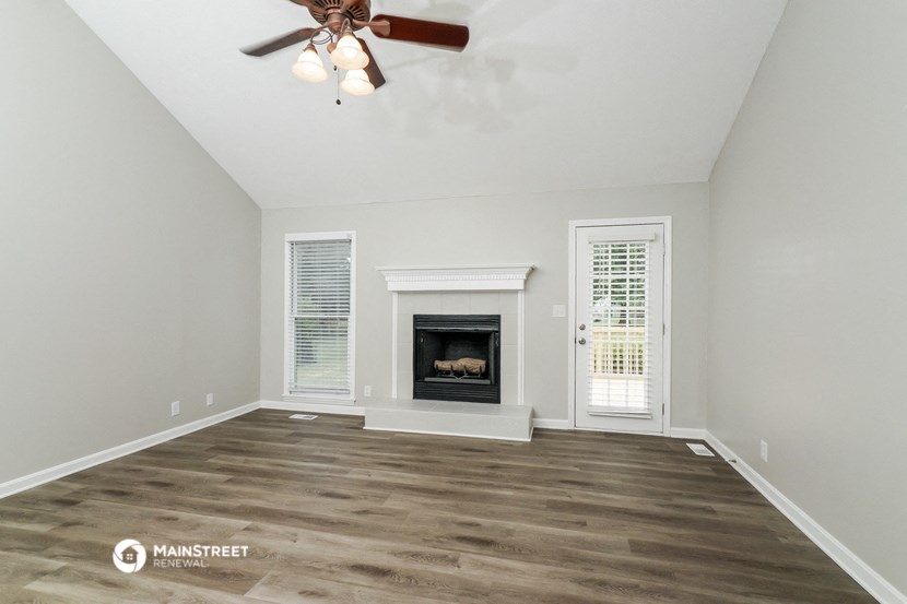 the living room with fireplace and ceiling fan