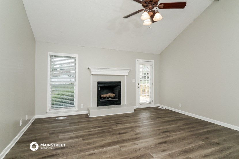 the living room with fireplace and ceiling fan