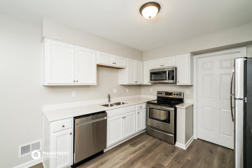 a kitchen with white cabinets and stainless steel appliances