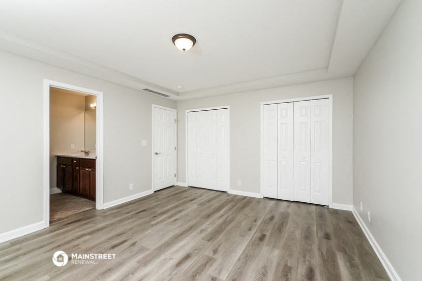 an empty living room with white walls and wood flooring