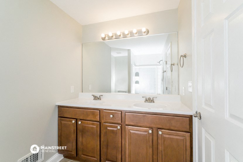 a bathroom with wooden cabinets and a sink and a mirror