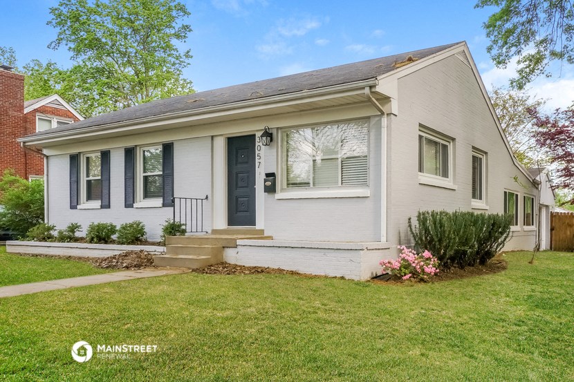 a white house with a blue door and a lawn