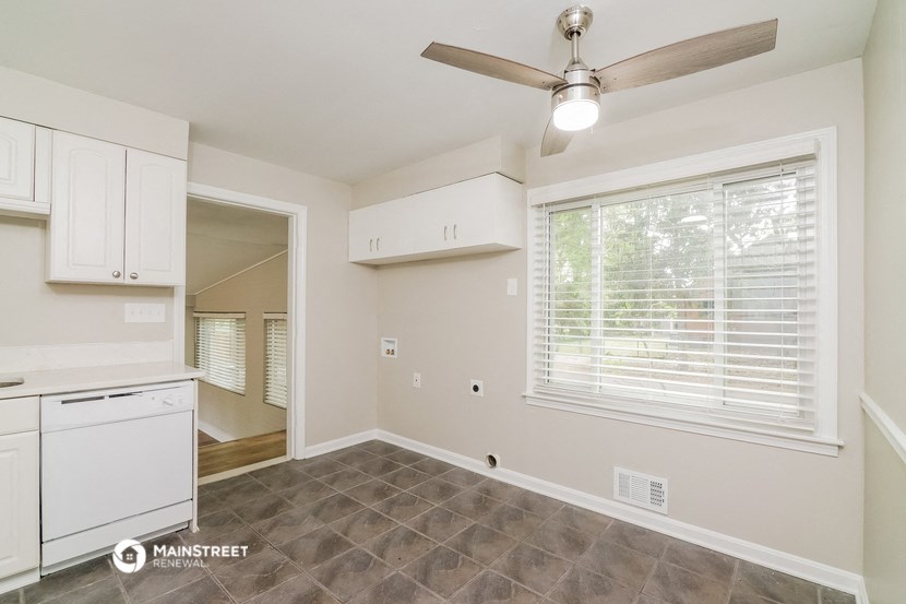a kitchen with white cabinets and a ceiling fan