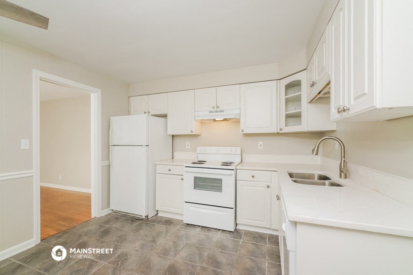 a white kitchen with white appliances and white cabinets