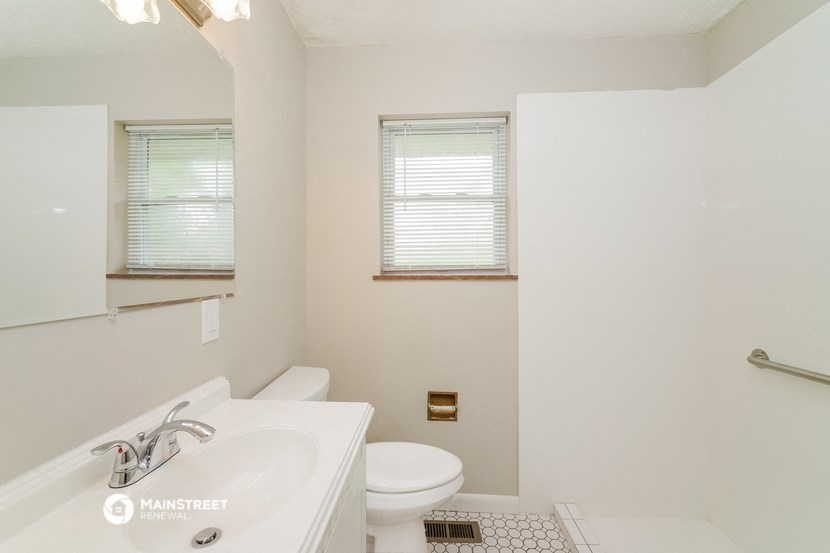 a bathroom with a sink toilet and a mirror