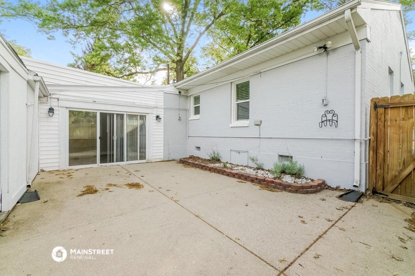 a white house with a patio and a wooden fence