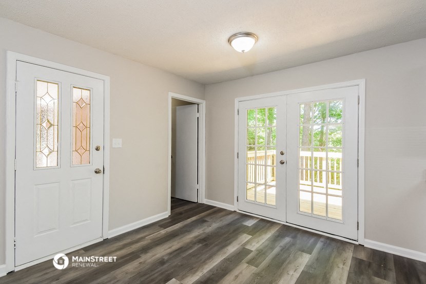 a living room with white doors and a door to a balcony
