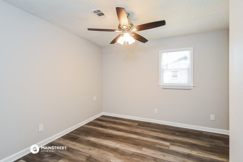 the interior of a bedroom with a ceiling fan and a window